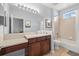 Clean bathroom features a double sink vanity with dark wood cabinets, a shower-tub combo, and tile flooring at 6532 Coopers Hawk Ct, Lakewood Ranch, FL 34202