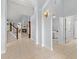 Spacious foyer with tiled floors, staircase, and a view of the living room with a cozy fireplace at 6532 Coopers Hawk Ct, Lakewood Ranch, FL 34202