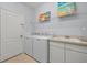 Bright laundry room equipped with utility sink, shelving and appliances at 6532 Coopers Hawk Ct, Lakewood Ranch, FL 34202
