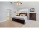Bedroom featuring a dark wood bed frame, a ceiling fan and a ensuite bathroom at 6532 Coopers Hawk Ct, Lakewood Ranch, FL 34202