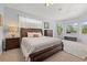 Spacious main bedroom featuring a dark wood bed frame, a ceiling fan and lots of windows at 6532 Coopers Hawk Ct, Lakewood Ranch, FL 34202