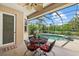 Covered patio with outdoor seating overlooks a screened-in pool and lush landscaping at 6532 Coopers Hawk Ct, Lakewood Ranch, FL 34202