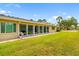 Expansive backyard featuring lush lawn, patio, and sunroom addition along the home's rear exterior at 6940 W Country Club N Dr # V-77, Sarasota, FL 34243