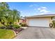 Charming home featuring lush landscaping, palm trees, and a welcoming two-car garage at 6940 W Country Club N Dr # V-77, Sarasota, FL 34243