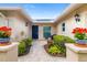 Covered entry featuring beautiful plants, a brick pathway, and stylish wall-mounted lighting at 6940 W Country Club N Dr # V-77, Sarasota, FL 34243