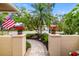 Covered entry with an American flag and beautiful plants flanking the tiled walkway at 6940 W Country Club N Dr # V-77, Sarasota, FL 34243