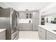 Modern kitchen features gray cabinets, stainless steel appliances, and a tile backsplash at 6940 W Country Club N Dr # V-77, Sarasota, FL 34243
