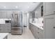 Gourmet kitchen boasts grey cabinets, stainless steel appliances, tile backsplash and updated countertops at 6940 W Country Club N Dr # V-77, Sarasota, FL 34243