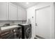 Laundry room featuring gray cabinets and modern washer and dryer at 6940 W Country Club N Dr # V-77, Sarasota, FL 34243