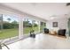 Bright sunroom featuring tile flooring, modern furniture, and large sliding glass doors to backyard at 6940 W Country Club N Dr # V-77, Sarasota, FL 34243