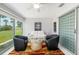Cozy sunroom with plush seating, decorative rug, and sliding glass doors overlooking manicured lawns at 6940 W Country Club N Dr # V-77, Sarasota, FL 34243