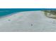 Wide shot of a beach with people enjoying the day near vacation rentals and resorts at 6951 Gulf Of Mexico Dr # 14, Longboat Key, FL 34228