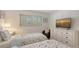 Comfortable bedroom with twin beds, shuttered windows, and a dresser with a TV offering a relaxing ambiance at 6951 Gulf Of Mexico Dr # 14, Longboat Key, FL 34228