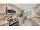 Well-lit kitchen featuring stainless steel appliances, light wood cabinets and laminate counters at 6951 Gulf Of Mexico Dr # 14, Longboat Key, FL 34228