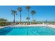 Inviting community pool with lounging area and clear views of the ocean and tropical palms at 6951 Gulf Of Mexico Dr # 14, Longboat Key, FL 34228