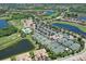 Community aerial view featuring golf course, tennis courts, pool, parking, and lush landscaping at 7019 Grand Estuary Trl # 101, Bradenton, FL 34212