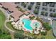 An aerial view of the community swimming pool with lounge chairs and palm trees at 7019 Grand Estuary Trl # 101, Bradenton, FL 34212