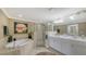 Luxurious bathroom featuring a soaking tub, glass-enclosed shower, and a double sink vanity for convenience at 7019 Grand Estuary Trl # 101, Bradenton, FL 34212