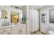 Bright bathroom with a large mirror, white cabinets and tiled shower at 7019 Grand Estuary Trl # 101, Bradenton, FL 34212