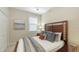 Cozy bedroom with a wooden headboard, soft pillows and serene decor at 7019 Grand Estuary Trl # 101, Bradenton, FL 34212