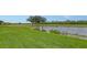 Picturesque golf course featuring a serene pond, manicured green lawns, and mature trees under a clear sky at 7019 Grand Estuary Trl # 101, Bradenton, FL 34212
