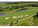 Scenic aerial view of the golf course featuring sand traps, water hazard and cart path at 7019 Grand Estuary Trl # 101, Bradenton, FL 34212