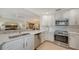 Bright kitchen boasts white cabinets, stainless steel appliances, and a seamless connection to the living area at 7019 Grand Estuary Trl # 101, Bradenton, FL 34212