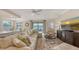 Spacious living room showcases a sectional sofa, entertainment center, and view of the golf course at 7019 Grand Estuary Trl # 101, Bradenton, FL 34212