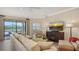 Bright living room features a comfortable sofa, TV, and access to outdoor area with golf course views at 7019 Grand Estuary Trl # 101, Bradenton, FL 34212