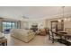 Open-concept living room and dining area with a comfortable sofa and access to the screened-in patio at 7019 Grand Estuary Trl # 101, Bradenton, FL 34212
