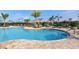 A community swimming pool with lounge chairs and umbrellas around the deck at 7019 Grand Estuary Trl # 101, Bradenton, FL 34212