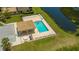 Aerial view of community pool, featuring a covered area, lounge chairs and a glimpse of a serene lake at 7019 Grand Estuary Trl # 101, Bradenton, FL 34212