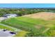 Aerial view of the golf course driving range with multiple golfers practicing their swings at 7441 Myrica Dr, Sarasota, FL 34241