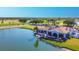 Stunning aerial view of the golf course clubhouse with a lake and golfers enjoying a sunny day at 7441 Myrica Dr, Sarasota, FL 34241