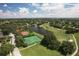 Aerial view of the golf course, tennis courts, neighborhood, and lake, creating a picturesque landscape at 7441 Myrica Dr, Sarasota, FL 34241