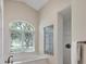 Cozy bathroom features soaking tub, glass block window, and shower with tile surround at 7441 Myrica Dr, Sarasota, FL 34241