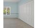 This bedroom features carpeted floors, blue walls, and a large closet at 7441 Myrica Dr, Sarasota, FL 34241