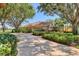 Stunning one-story home featuring a tile roof, a long driveway, and lush tropical landscaping at 7441 Myrica Dr, Sarasota, FL 34241