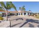 Exterior view of golf clubhouse featuring a covered cart drop off and tropical landscaping at 7441 Myrica Dr, Sarasota, FL 34241