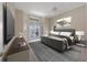 Staged main bedroom with large bed, TV, ceiling fan, neutral walls and door leading to pool at 7441 Myrica Dr, Sarasota, FL 34241