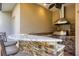 Outdoor kitchen features a stone backsplash, granite countertops, and a stainless steel grill at 7441 Myrica Dr, Sarasota, FL 34241