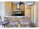 Outdoor kitchen features a stone backsplash, granite countertops, and a stainless steel vent hood at 7441 Myrica Dr, Sarasota, FL 34241