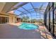 Screened-in pool area with a uniquely shaped pool, spa, and a covered outdoor kitchen at 7441 Myrica Dr, Sarasota, FL 34241