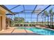 Screened-in pool area with a uniquely shaped pool, spa, and outdoor landscape at 7441 Myrica Dr, Sarasota, FL 34241