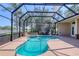Screened-in pool area with a uniquely shaped pool and view of a beautiful pond at 7441 Myrica Dr, Sarasota, FL 34241