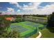 Aerial view of well-maintained tennis courts next to a lake and lush landscaping in a golf course community at 7441 Myrica Dr, Sarasota, FL 34241
