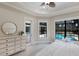 Bright bedroom features tray ceiling, ceiling fan, and pool view, seamlessly blending indoor comfort with outdoor allure at 7532 Greystone St, Lakewood Ranch, FL 34202
