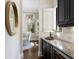 Cozy Butler's pantry featuring dark cabinetry, granite countertops, and a wine cooler at 7532 Greystone St, Lakewood Ranch, FL 34202