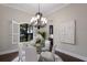 Bright dining room with glass table, modern chandelier, and views from the window at 7532 Greystone St, Lakewood Ranch, FL 34202