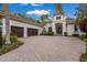 Stunning home featuring a well-manicured lawn, three-car garage, and an inviting double door entrance at 7532 Greystone St, Lakewood Ranch, FL 34202